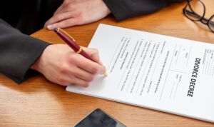 DIVORCE DECREE. Woman sign the paper. Lawyer, notary office, close up above view